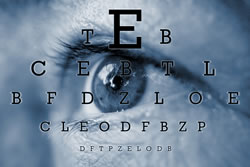 Foto: Ein Auge hinter den Buchstaben einer Sehtesttafel