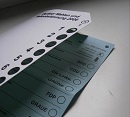 Muster einer Wahlschablone mit eingelegtem Stimmzettel aus Berlin Das Bild zeigt eine Wahlschablone