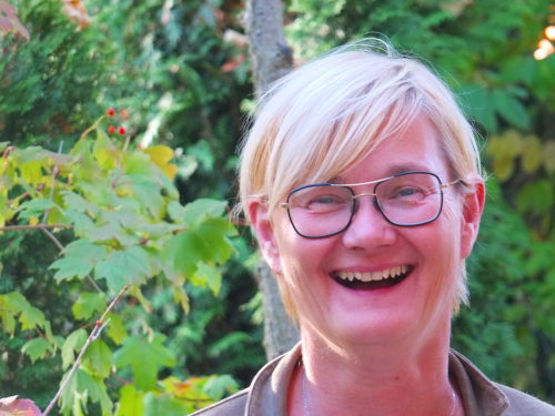 Die Beraterin Monika Stiebing steht lächelnd im Grünen