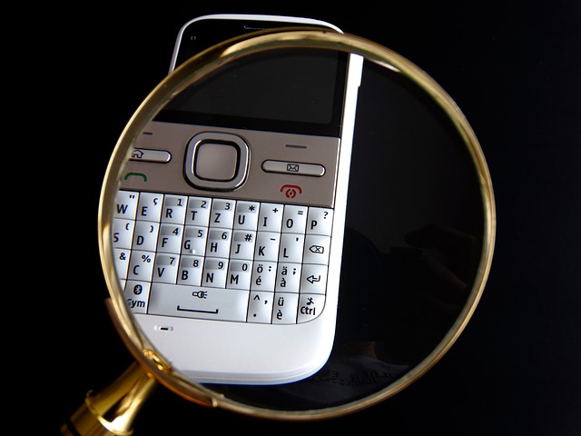 Eine Lupe vergrößert die Tastatur eines Handys. Quelle: Pixabay