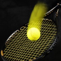 Das Foto zeigt einen Tennisball, der auf einem Tennisschläger springt