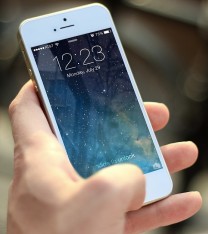 Das Foto zeigt eine Hand, die ein Smartphone hält